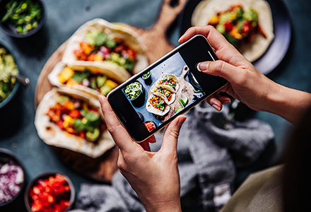 Person taking a photo of a meal with a mobile phone