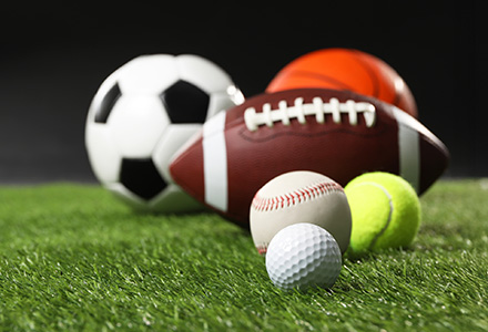 A series of game balls on a field of green grass
